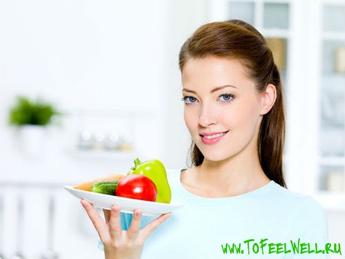 девушка держит тарелку с овощами
