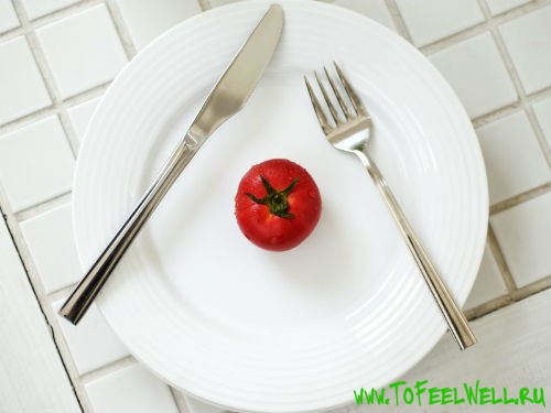 помидор лежит на белой тарелке