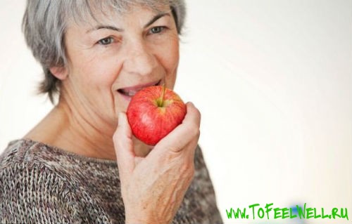 пожилая женщина есть красное яблоко