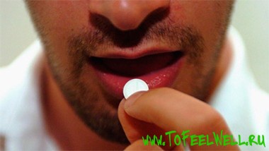 мужчина кладет таблетку в рот