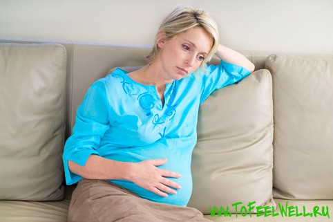 беременная девушка сидит на диване