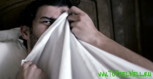 мужчина закрывает лицо одеялом